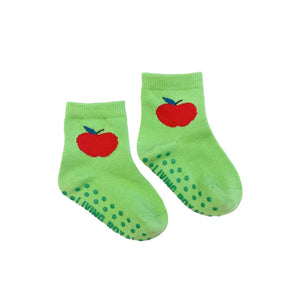 Close-up of a pair of lime green baby socks with a red apple and non-slip grips.