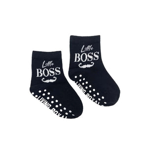 Flat lay product shot showing a pair of 'Little Boss' baby socks with grippers on the soles.
