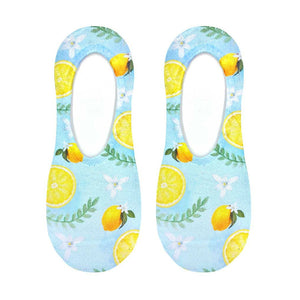 Flat lay product shot of a pair of Classy Lemon no-show socks, showcasing the full lemon and floral print design on a light blue background.