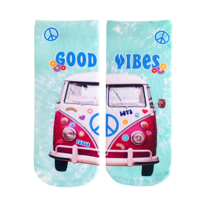 A pair of teal tie-dye crew socks.  They feature a pink VW bus with peace signs and flower stickers. The words 'Good Vibes' are displayed. }}