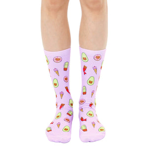 Lavender crew socks with an all-over print of illustrated cats dressed as avocados, ice cream cones, donuts, and cacti.