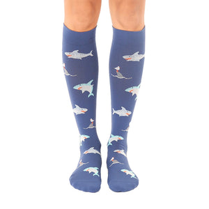 Pair of blue knee-high socks with a repeating pattern of cartoon sharks. Sharks are in teal, white, and orange.