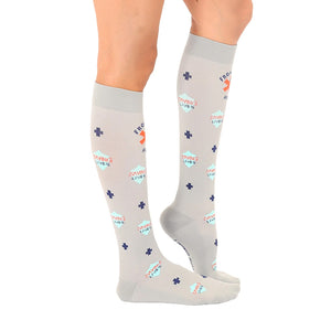 A pair of gray medical compression socks with a pattern of blue and coral plus signs and the words 