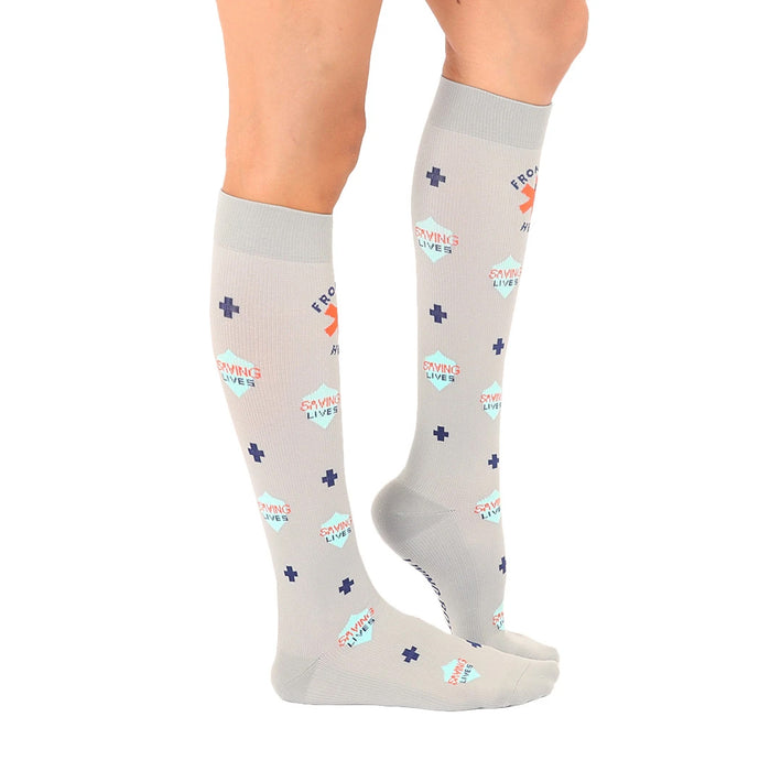 A pair of gray medical compression socks with a pattern of blue and coral plus signs and the words 
