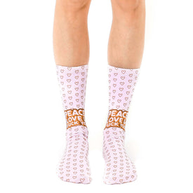 pink and brown heart pattern socks with "peace love fuck you" in brown letters. unisex crew socks.   