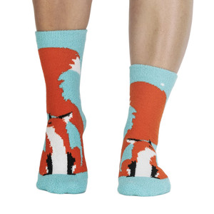 Pair of fox slipper socks on a person's legs.
