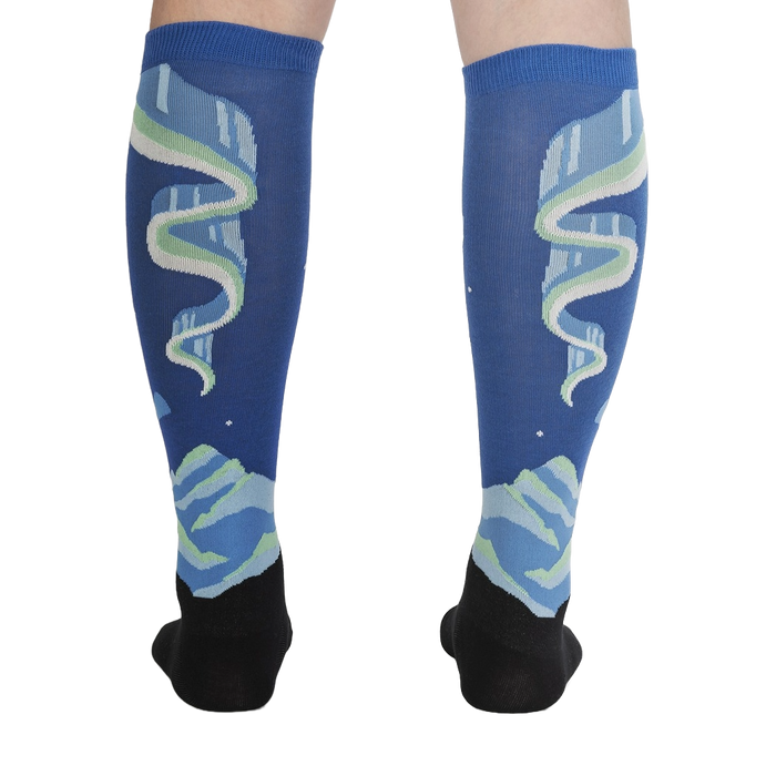 Rear view of the socks on a model's legs, highlighting the symmetrical design and glow-in-the-dark feature.