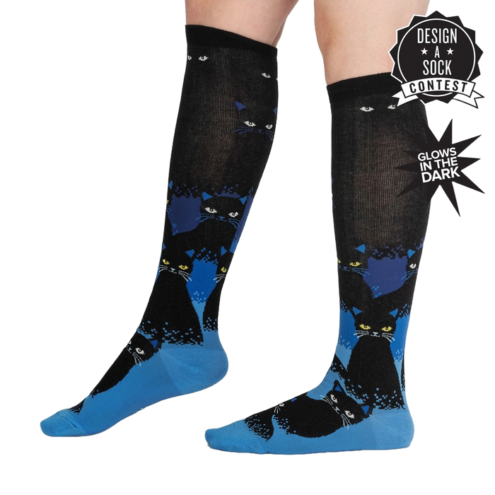 Lifestyle shot showing the socks on a person's legs, highlighting their length and glow-in-the-dark feature.