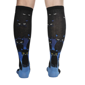 Rear view of the socks on a person's legs, showcasing the full design and cat pattern.