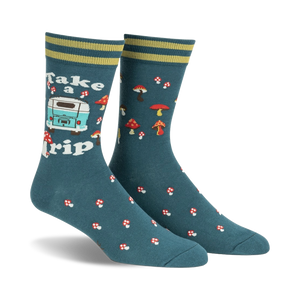 Pair of teal crew socks with a retro camper van, mushrooms, and the text 'Take a Trip'. Yellow and green stripes at the cuff.