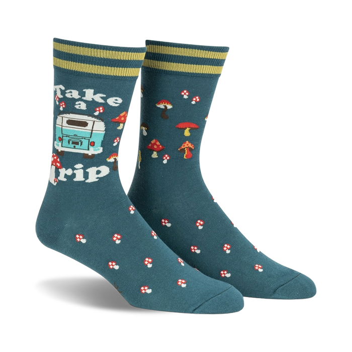 Pair of teal crew socks with a retro camper van, mushrooms, and the text 'Take a Trip'. Yellow and green stripes at the cuff.