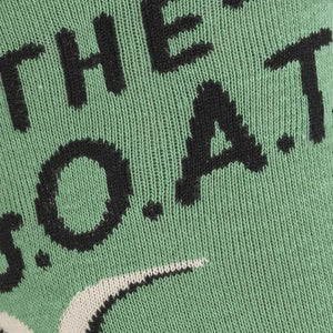 Close-up of the sock's knit texture showing the 'The G.O.A.T.' text and a goat's head.