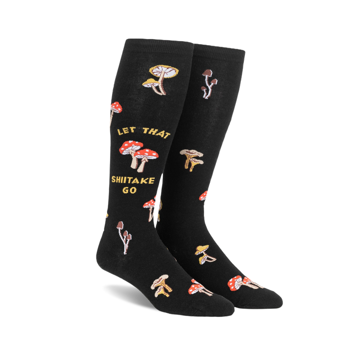Pair of black knee-high socks with a whimsical design. Features various illustrated mushrooms and the text 'Let That Shiitake Go'.
