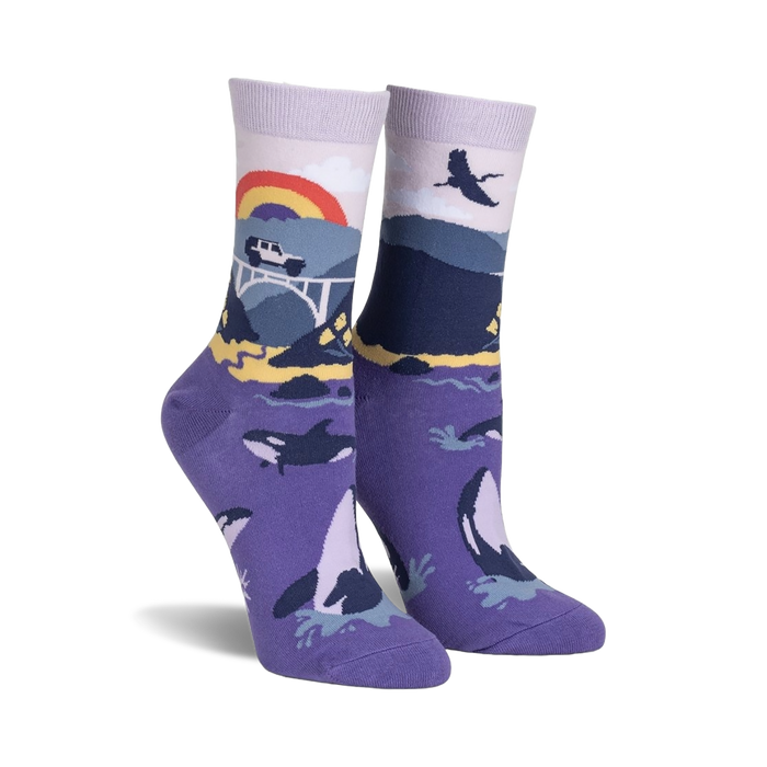 Pair of purple crew socks with a Big Sur-inspired design.  Features whales, a bridge, a rainbow, and coastal mountains.