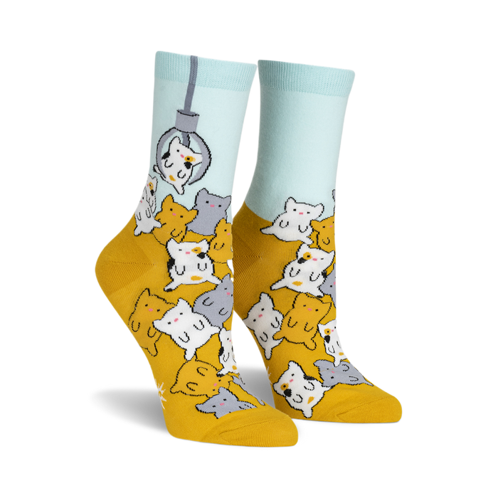 socks with a pattern of cats in claw vending machine grabbers. the cats are multi-colored and the background is yellow. socks that are mostly yellow and have a light blue cuff. }}