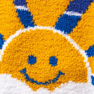 Close-up detail of the smiling sun face on the sock.