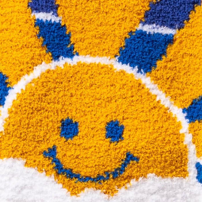 Close-up detail of the smiling sun face on the sock.