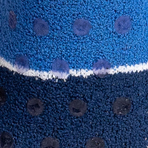 Close-up texture shot of the fuzzy blue and darker blue sock fabric with gripper dots.