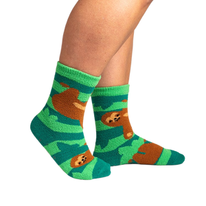 Lifestyle photo showing the socks on a person's feet.  The socks are teal and green with brown sloths.