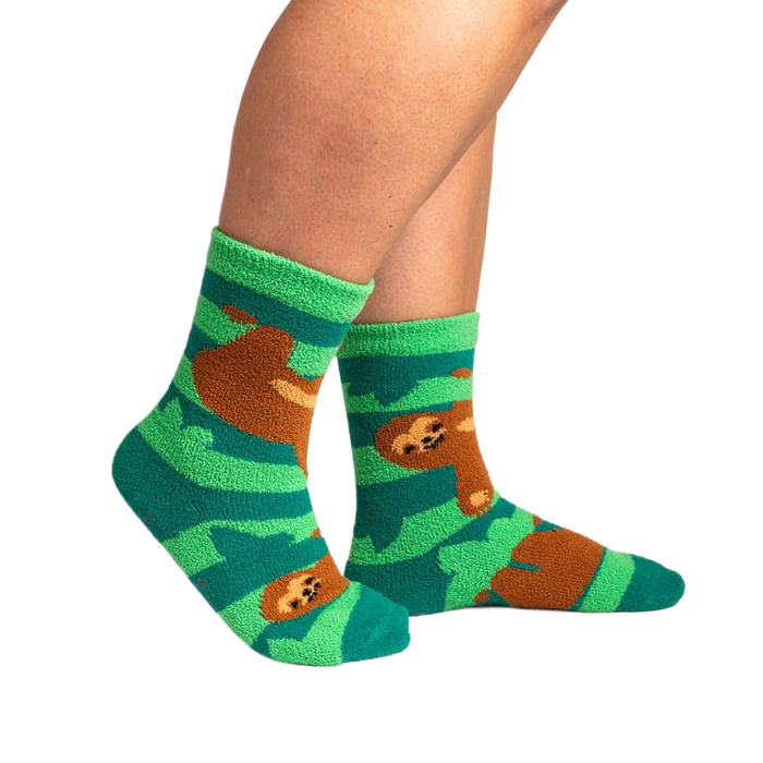 Lifestyle photo showing the socks on a person's feet.  The socks are teal and green with brown sloths.