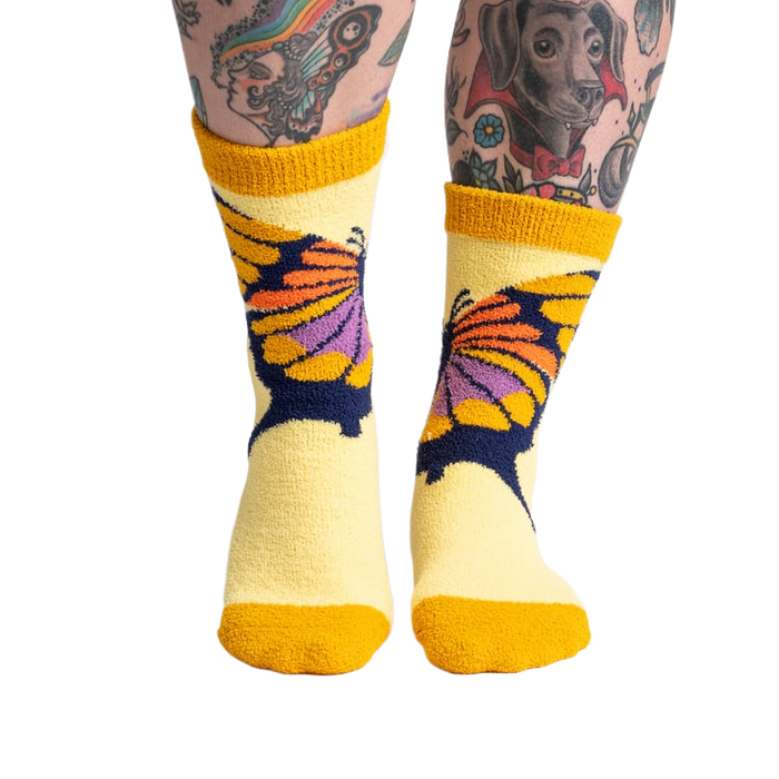 Lifestyle shot of a person wearing the yellow butterfly slipper socks, showcasing the fit and feel.