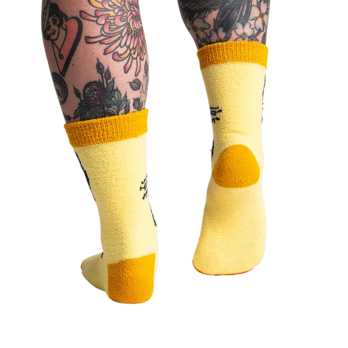 Back view of the yellow butterfly socks; highlighting the mustard yellow cuff and heel.