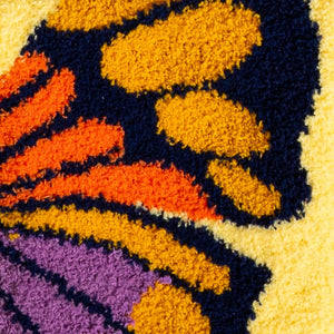 Close-up of the detailed butterfly wing design on the socks, showing the texture and color variations.