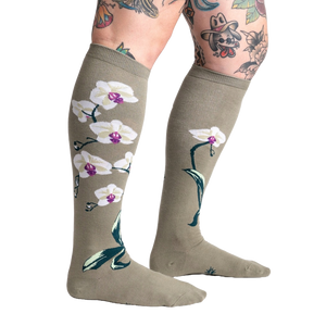 Lifestyle shot showcasing Orchid knee-high socks on a model with tattoos, highlighting the socks' length and design.