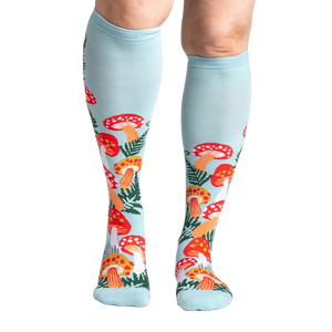 Lifestyle shot showcasing the Wonderland Mushrooms knee-high socks on a model's legs.