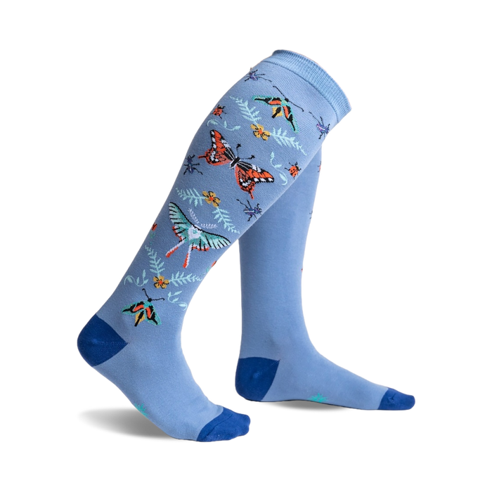 A pair of light blue knee-high socks adorned with colorful butterflies, ladybugs, and floral accents.