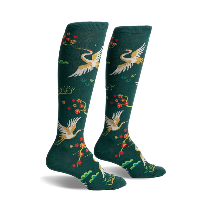 Pair of women's knee-high socks in hunter green. Features gold cranes, red blossoms, and green foliage.
