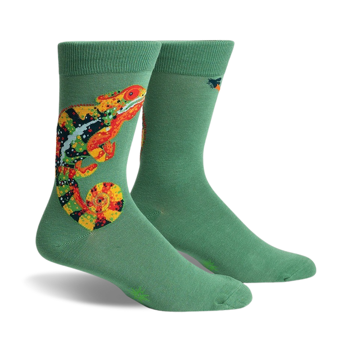 Pair of sage green crew socks with a colorful chameleon design. The chameleon is orange, yellow, and black.
