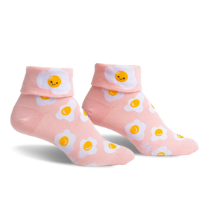 Pair of pink ankle socks featuring a whimsical all-over print of smiling fried eggs.  The socks have a folded-over cuff.