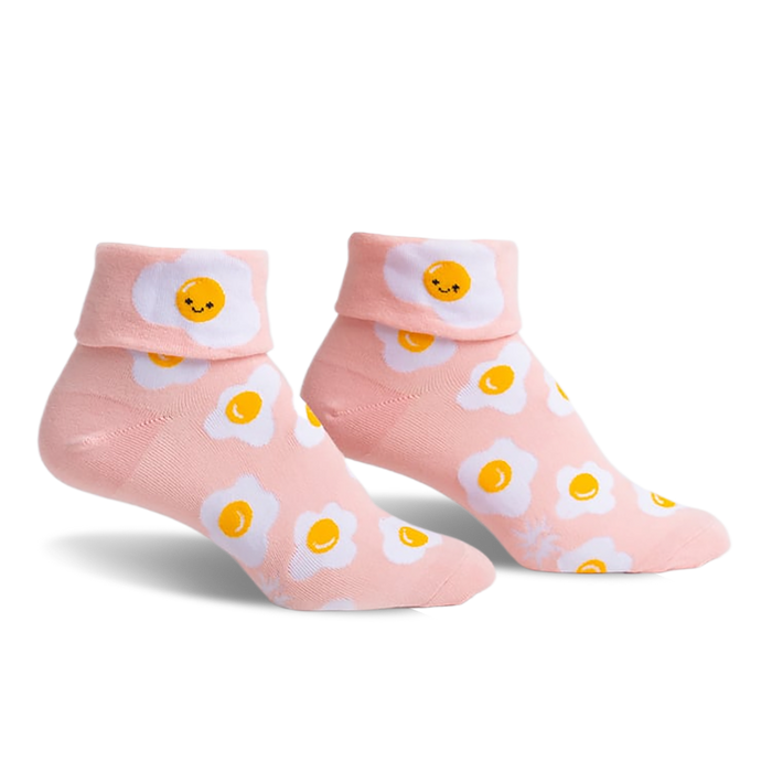 Pair of pink ankle socks featuring a whimsical all-over print of smiling fried eggs.  The socks have a folded-over cuff.