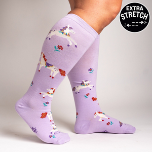 Lifestyle shot showing the lavender unicorn socks on a person's legs, highlighting the extra stretch.