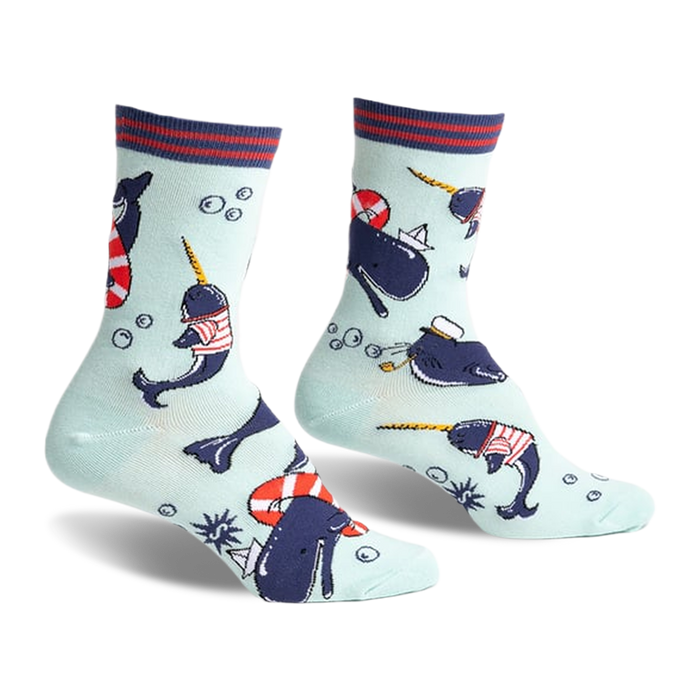 Crew socks featuring narwhals in sailor outfits, life preservers, and paper boats on a light blue background. Red, navy, and white details.