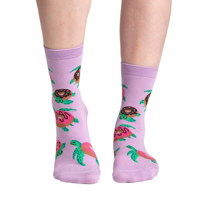 Lifestyle shot of model wearing a pair of lavender crew socks with turtles and donuts.