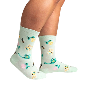Lifestyle shot of a person wearing the mint green 'Sow in Love' socks, showcasing how they look when worn.