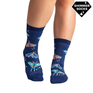 Lifestyle shot of a person's legs wearing the Moonlit Moth Shimmer socks, showing the socks on feet.