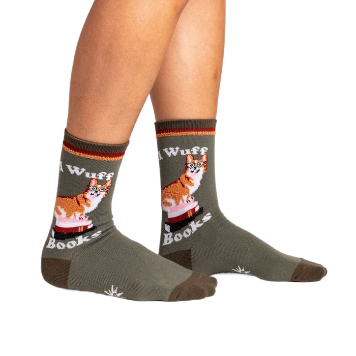 Lifestyle photo showing the socks on a person's legs. The socks are olive green with a corgi design.