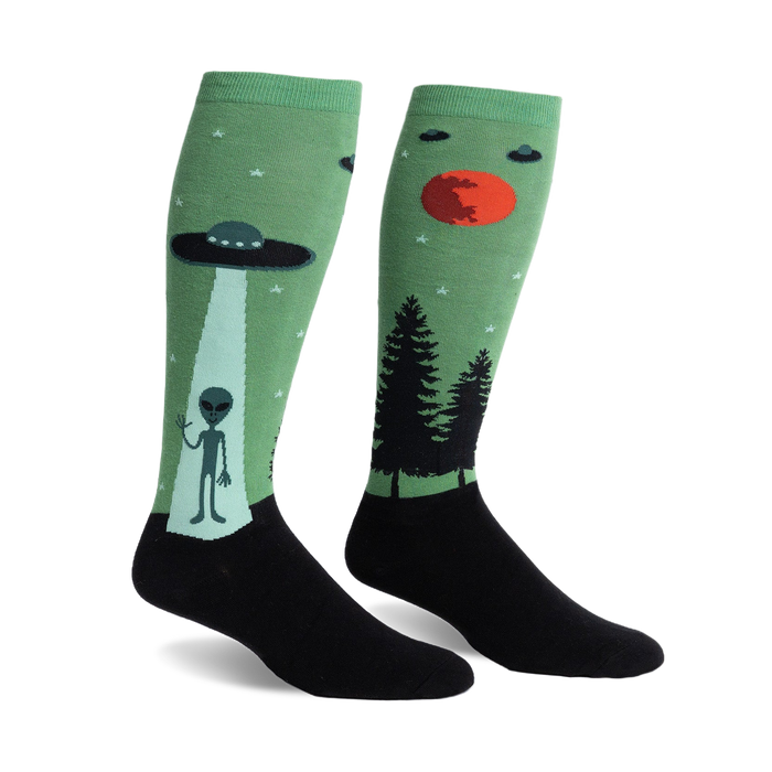 Pair of green and black knee-high socks featuring an alien, UFO, and forest scene.