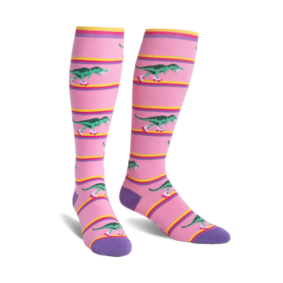 Knee-high socks in pink with purple cuffs.  Design features green T-Rexes on roller skates skating across pink and yellow stripes.