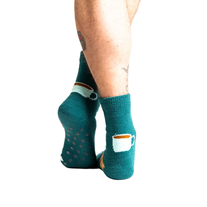Back view of model wearing teal blue coffee and croissant slipper socks.