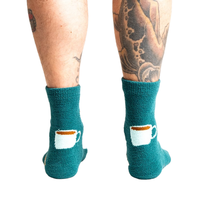 Close-up shot of the back of the teal blue coffee and croissant slipper socks.
