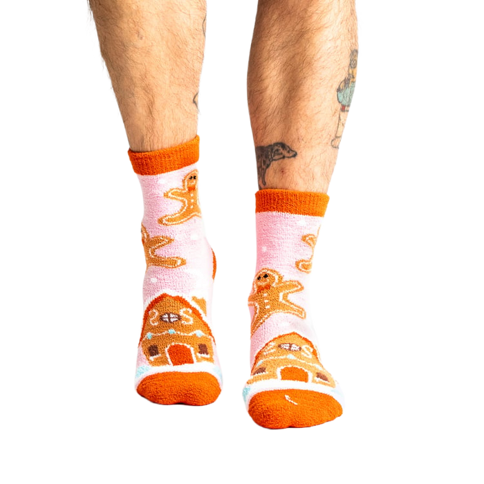 Lifestyle shot of a person wearing the pink gingerbread slipper socks.