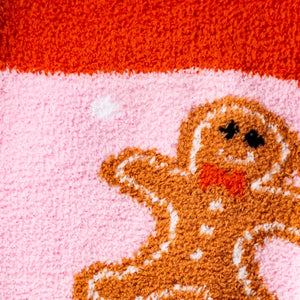 Detailed close-up of the gingerbread man design on the pink fuzzy socks.