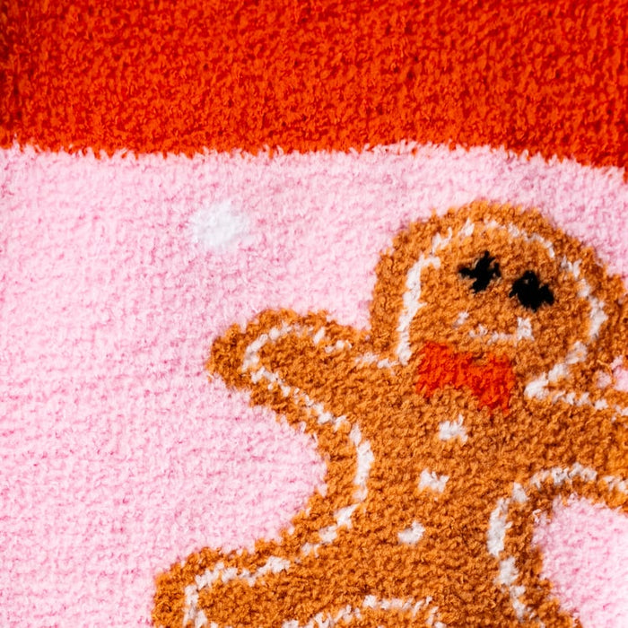 Detailed close-up of the gingerbread man design on the pink fuzzy socks.