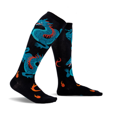Pair of black knee-high socks with teal dragons and orange flames. Fun and vibrant design.