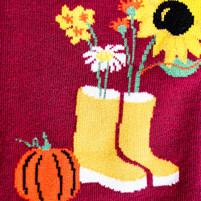 Close-up detail shot of Autumn Harvest sock design featuring yellow boots and a pumpkin.
