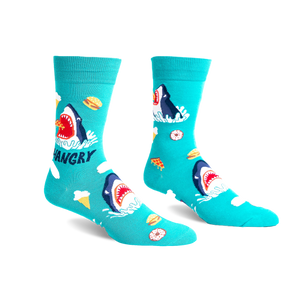 Pair of teal crew socks with a graphic design of a hungry shark surrounded by pizza, ice cream, and burgers.